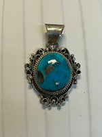Navajo handcrafted sterling silver pendant with genuine turquoise stone.  LZ302